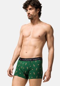 Zielone bokserki z wzorem butelek piwa. Wykonane z miękkiego materiału, z czarnym elastycznym pasem oznaczonym "LANČERTO."