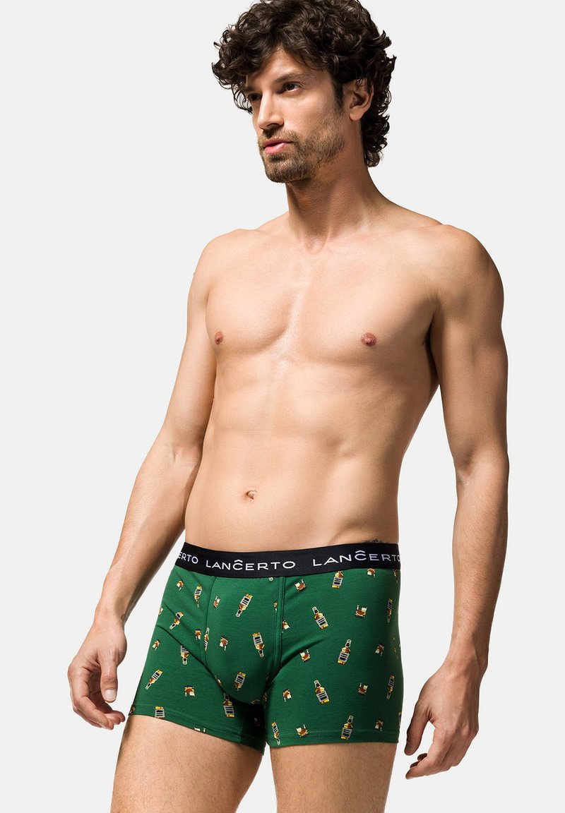 Zielone bokserki z wzorem butelek piwa. Wykonane z miękkiego materiału, z czarnym elastycznym pasem oznaczonym "LANČERTO."