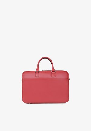 Mallette en cuir rouge avec deux poignées, une poche avant et une fermeture éclair argentée sur le dessus, présentée sur un fond blanc.