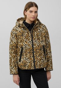 Tijgerprint pufferjack in bruin en zwart; heeft een capuchon, een ritssluitingen voorzijde, twee ritssluitingen zijzakken en een gewatteerde textuur.