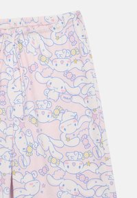 Rosa Stoff mit Cartoon-Gesichtern von Hasen und Bären, gelben und rosa Süßigkeiten, Sternen und Sprechblasen mit den Mustern "Huh?" und "Hmmm...".