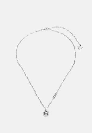 Silver chain necklace featuring a round pendant with a central stone, adorned with a circular border. Includes a small logo tag at the clasp.