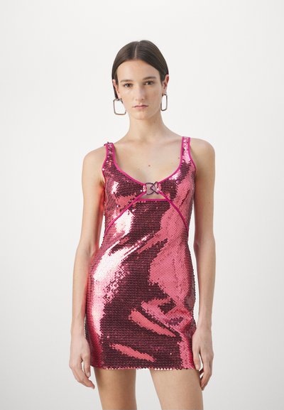 Vestido mini de lentejuelas rosas con escote en forma de barco y tirantes estrechos, que presenta un detalle de hebilla decorativa en el centro delantero. Textura suave.