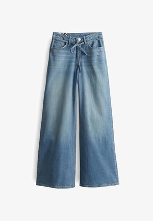 Jeans a gamba larga in denim blu chiaro, con vita regolabile, tasche frontali e trattamento lavato. Cuciture distintive lungo le cuciture.
