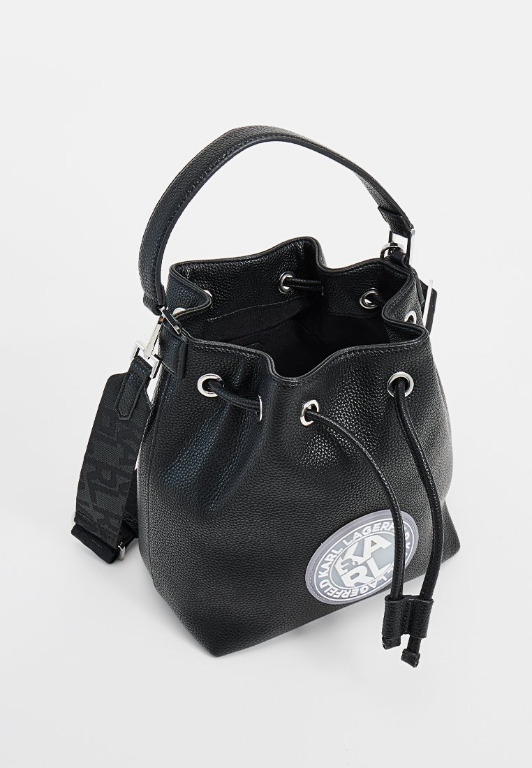 Schwarze Leder-Eimer-Tasche mit strukturierter Oberfläche, runder Logodetail, silberfarbener Hardware und Kordelzugverschluss. Enthält einen kurzen Griff und einen langen Schulterriemen.