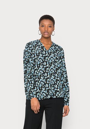 Blusa preta de mangas longas com um padrão floral em azul claro e verde, com decote em V e mangas franzidas, usada com calças pretas.