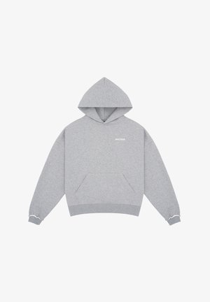 Persoon die een grijze hoodie draagt met voorzak en bijpassende grijze shorts met trekkoord, witte sokken en witte sneakers.