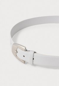 Valge nahkne vö�ö tekstuuriga pinnaga ja hõbedase metallist pannaliga. Omab konksu sulgemist ja väikseid reguleerimisharusid piki rihma.