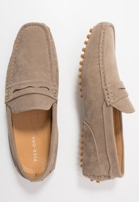 Gray suede loafers with a moccasin design, featuring contrasting stitching, a slip-on style, and rubber sole with textured nubs for grip.