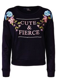 Felpa nera con testo "CUTE & FIERCE". Presenta un ricamo floreale colorato sulle spalle. Tessuto morbido, vestibilità comoda, scollatura rotonda.