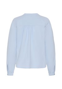 Chemise bleu clair à manches longues vue de dos, avec tissu froncé sous l’empiècement et poignets boutonnés.