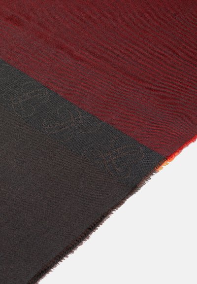 Vuna šal u postepenom prelazu crvene, narančaste i crne boje. Crni deo sadrži suptilan reljefni uzorak duž jednog ruba.