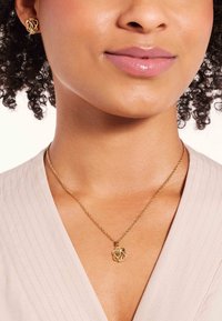 Goldschmuckset mit einem gedrehten Knotendesign. Die Ohrringe sind klein und die Halskette besitzt einen passenden Anhänger an einer zarten Kette.