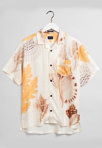Korte mouw overhemd met schelp- en koraalpatronen in beige, bruin en oranje tinten, hangend aan een witte hanger.