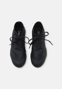 Black athletic shoes with a textured mesh upper, accentuated by smooth overlays, featuring a lace-up design and a molded rubber sole.