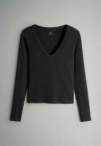 Melna garām piedurknēm V-veida kakla katra, izgatavota no mīksta kokvilnas auduma. Gluda tekstūra un pieguļošs dizains ar īsu apakšmalu.