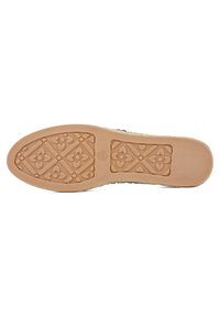 Zool van een schoen met een getextureerd rubberoppervlak, voorzien van een geometrisch patroon van harten en bloempatronen in beige en lichtbruin.
