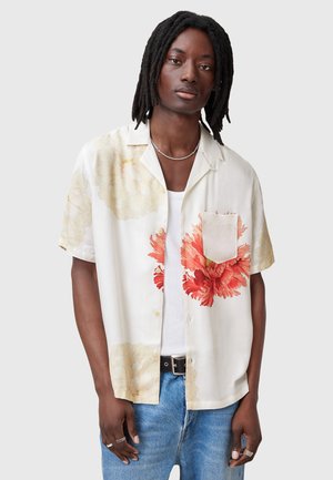 Camisa de manga corta floral en crema con estampados de flores rojas y rosas. Incluye un bolsillo en el pecho, tejido suave y un corte relajado.