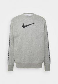 Šedá mikina s kulatým výstřihem, černé logo Nike na hrudi a pruhované černé akcenty podél rukávů. Měkká textilie.