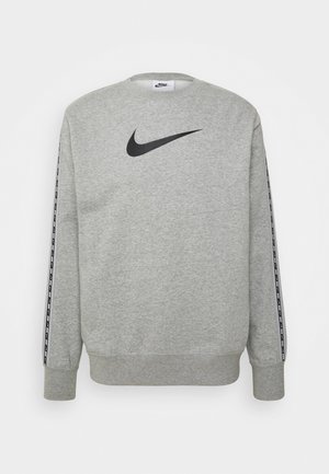 Sudadera gris con cuello redondo, logo negro de Nike en el pecho, y rayas negras a lo largo de las mangas. Textura de tela suave.