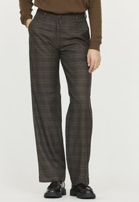 Pantalons à carreaux marron en tissu léger, avec une coupe droite, des poches avant et des lignes orange contrastantes dans le motif.