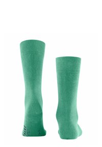 Groene kniesokken met een gladde textuur en geribbelde boorden. Opvallende brandingdetail aan de zijkant in het zwart.