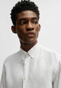 Witte linnen shirt met een button-down kraag, met een gestructureerde afwerking en twee knopen bij de hals voor sluiting.