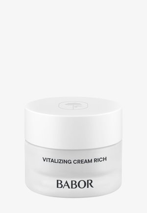 Crème revitalisante dans un pot en verre transparent avec un couvercle blanc. Surface lisse, forme ronde, avec du texte noir pour le branding du produit.