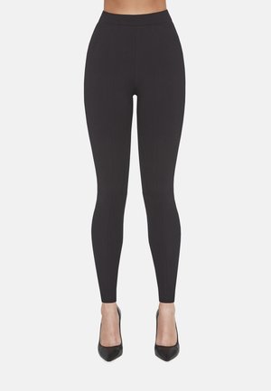 Czarne legginsy z wysokim stanem, wykonane z elastycznego materiału, z pionowymi szwami i płaskim, dopasowanym krojem.