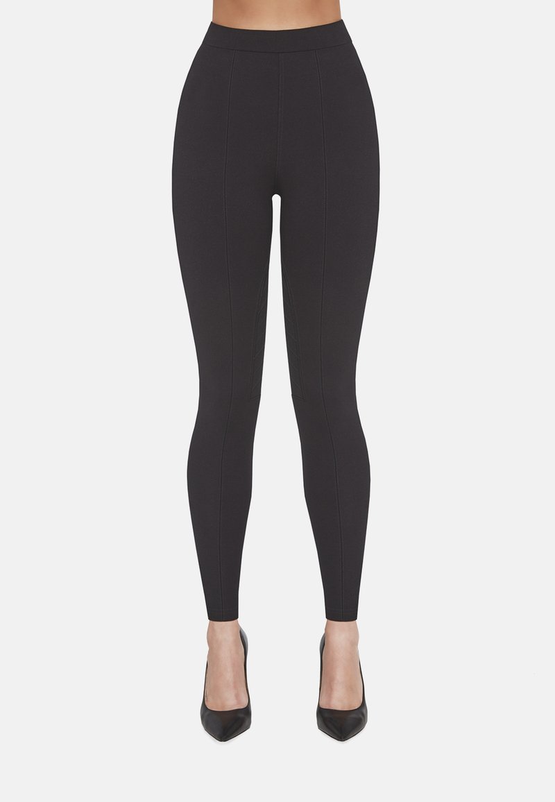 Czarne legginsy z wysokim stanem, wykonane z elastycznego materiału, z pionowymi szwami i płaskim, dopasowanym krojem.