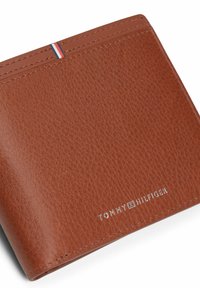 Cartera de cuero marrón con superficie texturizada, con detalle de franjas en blanco, rojo y azul, y logo plateado de "TOMMY HILFIGER".