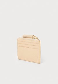 Pali bež kožni držač za kartice s teksturiranom površinom, koji ima tri utora za kartice i zip zatvoren odjeljak za kovanice.