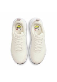 Crèmekleurige sportschoenen met een gestructureerde bovenkant van stof, witte zool en een subtiele roze accent bij de hiel. Vetersluiting en logo op de binnenzool.