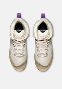 Wysokie buty wspinaczkowe w kolorze off-white z teksturowanymi panelami, beżowymi akcentami i fioletowymi pętlami do sznurowania. Posiadają wyściełane wnętrze oraz wzorzyste sznurówki.