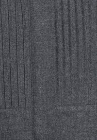 Tissu en laine grise avec des plis verticaux, présentant une texture douce et un motif subtil en chevrons. Aucun objet ni personne visible.
