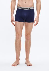 Calzoncillos tipo bóxer de color azul marino con una cintura elástica plateada que lleva el logo "KARL LAGERFELD", fabricados con un tejido de punto suave y elástico.