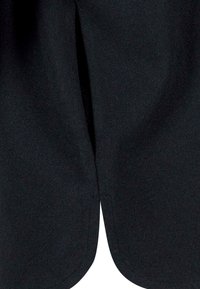 Zwarte stoffen shorts met een gladde textuur, featuring een centrale split aan de onderkant voor bewegingsgemak en een strakke, op maat gemaakte uitstraling.