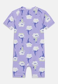 Combinaison à manches courtes lavande avec un motif floral en blanc, vert et bleu. Tissu lisse et extensible, conçu pour le confort et la mobilité.