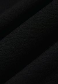 Czarny materiał o teksturowanym splocie, z widocznymi zagnieceniami i fałdami, podkreśla matowe wykończenie. Brak widocznych wzorów lub dodatkowych detali.