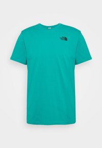 Camiseta turquesa de manga corta hecha de algodón con cuello redondo. Presenta un logo negro en el área del pecho izquierdo. Diseño sencillo, sin patrones.