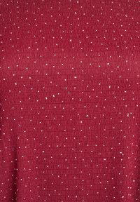 Tissu texturé bordeaux présentant un motif à côtes avec de de petits points blancs réfléchissants distribués uniformément sur la surface.