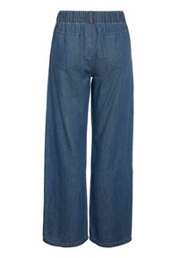 Pantaloni denim albaștri cu croială largă și talie elastică, cu două buzunare aplicate în spate, văzuți din spate pe un fundal alb.