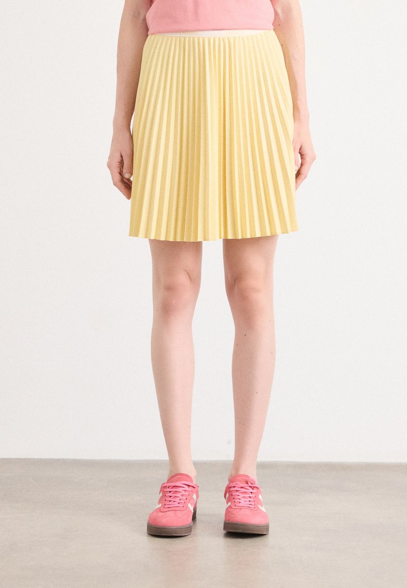 Gonna gialla plissettata con vita alta, di lunghezza al ginocchio, realizzata in un tessuto leggero; texture liscia con un motivo uniforme su tutta la superficie.