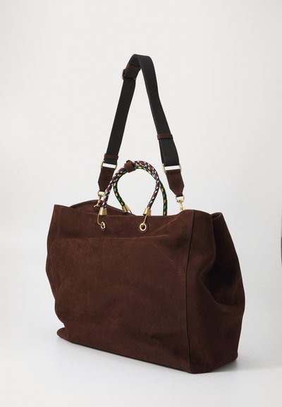 Geantă tote din suede maro cu o curea neagră și un mâner colorat țesut. Prezintă accesorii din aur și un design spațios, moale.