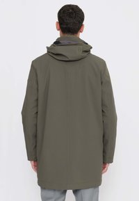 Cappotto impermeabile verde oliva con cappuccio, maniche lunghe e taglio dritto, caratterizzato da una texture liscia e un design minimalista.