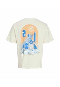T-shirt beige chiaro con grafica blu e arancione di scale, finestre, sole e vasi, con la scritta "Mykonos Pure Paradise" sulla schiena.