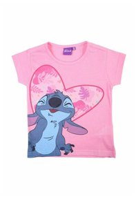 T-shirt en coton rose avec un personnage de dessin animé affichant une expression souriante, sur un fond en forme de cœur orné de motifs floraux.