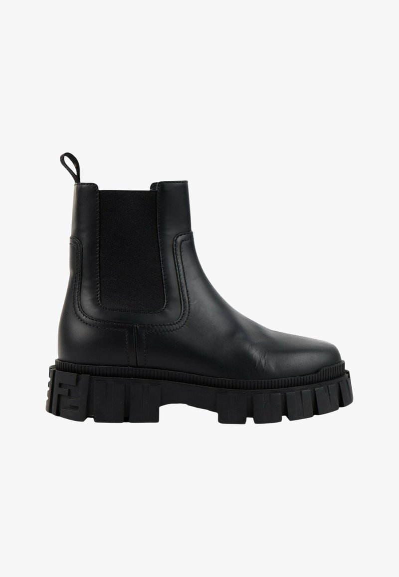 Bottine en cuir noir avec semelle épaisse et robuste, panneau latéral élastique et languette de maintien au talon, présentée de profil sur fond blanc.