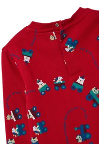 Camisa roja de manga larga con divertidos animales de dibujo animado en vehículos, con un cuello redondo y cierre de snaps en la parte posterior.