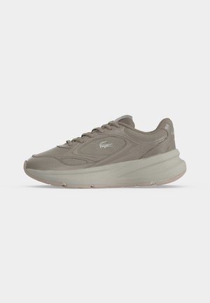 Chaussure de sport couleur taupe avec semelle épaisse, lacets à l'avant, panneaux en mesh et cuir, et petit logo crocodile sur le côté.